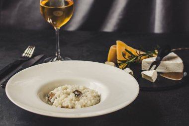 beyaz bir tabak ve bardak beyaz wineon karanlık bir arka plan risottowith midye (deniz ürünleri pirinç)
