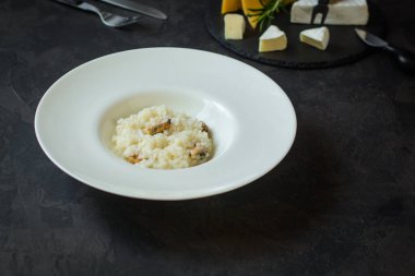 beyaz bir tabak ve bardak beyaz wineon karanlık bir arka plan risottowith midye (deniz ürünleri pirinç)