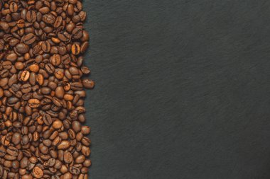 kahve çekirdekleri (tahıl) iyi ve kötü - arabica ve robusta (kavrulmuş kahve tahıl) karışımı. Siyah arka plan. Üstten görünüm. Kopya alanı.