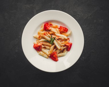 Penne makarna salça ve domates ile. Vegan gıda. (koyu arka plan). üstten görünüm. kopya alanı