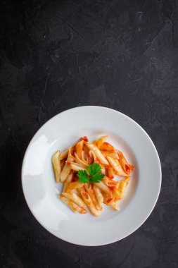 Penne makarna salça ve domates ile. Vegan gıda. (koyu arka plan). üstten görünüm. kopya alanı