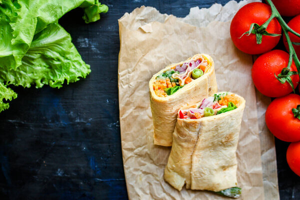 wrap tortilla or burrito stuffing vegetables vegetarian pita bread raw fish seafood in ice quick freeze Menu concept serving size. food background top view copy space for text organic healthy eating 