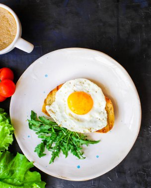 Kızarmış yumurta ve tost ekmeği salatası lezzetli kahvaltı aperatifi sarısı ve protein porsiyonu arka plan yemek servisi fotokopi alanı sağlıklı çiğ servis ediliyor.