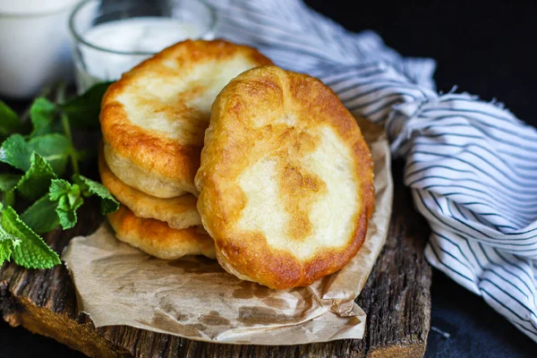 Düz ekmek tortillalarını un ve su kızartılmış hamur hamurundan paketle. Ev yapımı langolar, el yapımı yemekler, arka plan fotokopi alanı.