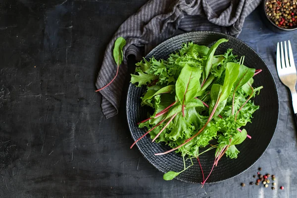 Healthy salad leaves mix salad micro greens, serving portion sizenatural juicy snack. food background keto or paleo diet raw