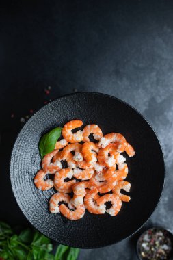 Karides kaynatılmış veya kızarmış deniz ürünleri yemeye hazır. Masanın üstünde kabuksuz. Metin diyeti için fotokopi alanı.