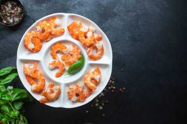 Karides kaynatılmış veya kızarmış deniz ürünleri yemeye hazır. Masanın üstünde kabuksuz. Metin diyeti için fotokopi alanı.