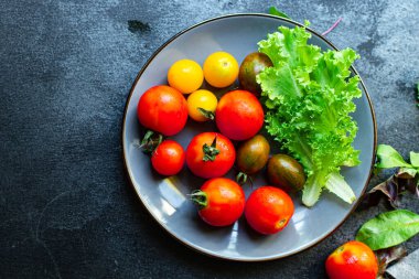 Çok renkli domates salatası sağlıklı organik malzemeler yiyin. Masada atıştırmalık bir şeyler pişirin. Lezzetli.