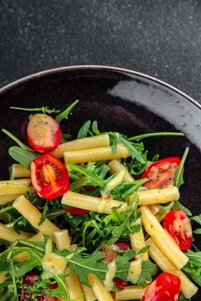pasta salad tomato, arugula, boiled pasta fresh food tasty healthy eating cooking appetizer meal food snack on the table copy space food background rustic top view