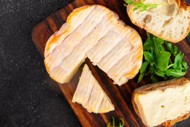 Yıkanmış kabuklu peynir portakal kabuklu yumuşak peynir Fransız peyniri lezzetli aperatif lezzetli gurme yemek arkaplanı masanın kırsal kesiminde fotokopi alanı.