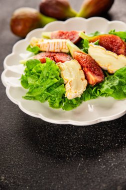 Salata inciri, yumuşak peynir, yeşil yaprak marul lezzetli aperatif lezzetli lezzetli gurme yemek arkaplan masa üzerinde rustik gıda üst görünüm fotokopi alanı keto ve paleo diyet vejetaryen gıda