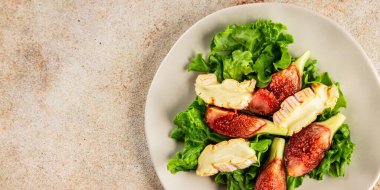 Salata inciri, yumuşak peynir, yeşil yaprak marul lezzetli aperatif lezzetli lezzetli gurme yemek arkaplan masa üzerinde rustik gıda üst görünüm fotokopi alanı keto ve paleo diyet vejetaryen gıda
