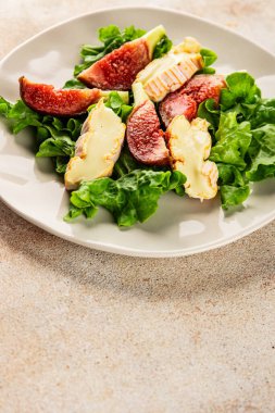 Salata inciri, yumuşak peynir, yeşil yaprak marul lezzetli aperatif lezzetli lezzetli gurme yemek arkaplan masa üzerinde rustik gıda üst görünüm fotokopi alanı keto ve paleo diyet vejetaryen gıda