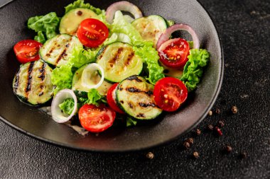 Salata ızgara kabak, domates, marul, lezzetli aperatif lezzetli lezzetli gurme yemek arkaplan masa üzerinde rustik gıda üst görünüm fotokopi alanı keto ve paleo diyet vegan ve vejetaryen gıda