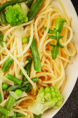 Spagetti sebzesi, bezelye, brokoli, çalı fasulyesi, kohlrabi vejetaryen makarna lezzetli makarna masanın üzerinde taze lezzetli gurme yemek.