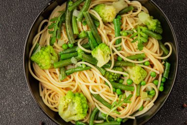 Spagetti sebzesi, bezelye, brokoli, çalı fasulyesi, kohlrabi vejetaryen makarna lezzetli makarna masanın üzerinde taze lezzetli gurme yemek.