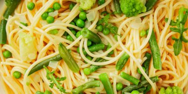 Spagetti sebzesi, bezelye, brokoli, çalı fasulyesi, kohlrabi vejetaryen makarna lezzetli makarna masanın üzerinde taze lezzetli gurme yemek.