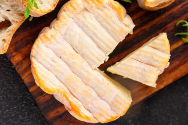 Yıkanmış kabuklu peynir portakal kabuklu yumuşak peynir Fransız peyniri lezzetli aperatif lezzetli gurme yemek arkaplanı masanın kırsal kesiminde fotokopi alanı.