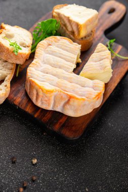 Yıkanmış kabuklu peynir portakal kabuklu yumuşak peynir Fransız peyniri lezzetli aperatif lezzetli gurme yemek arkaplanı masanın kırsal kesiminde fotokopi alanı.