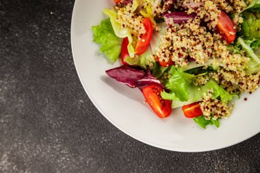 Kinoa salatası domates, yeşil yaprak salatası sebzeler... doğal ürün... lezzetli çerez... lezzetli gurme yemek... masanın üstünde... rustik üst görünüm... fotokopi alanı keto... ve paleo diyet vegan ve vejetaryen yiyecekler.