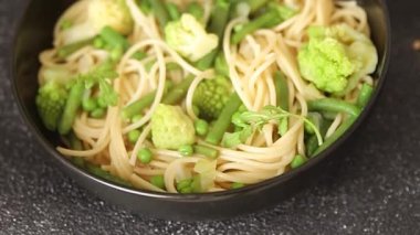 Spagetti sebzesi, bezelye, brokoli, çalı fasulyesi, kohlrabi vejetaryen makarna lezzetli makarna masanın üzerinde taze lezzetli gurme yemek.