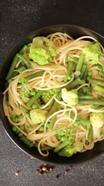 Spagetti sebzesi, bezelye, brokoli, çalı fasulyesi, kohlrabi vejetaryen makarna lezzetli makarna masanın üzerinde taze lezzetli gurme yemek.