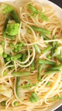 Spagetti sebzesi, bezelye, brokoli, çalı fasulyesi, kohlrabi vejetaryen makarna lezzetli makarna masanın üzerinde taze lezzetli gurme yemek.