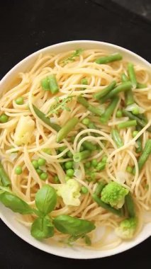 Spagetti sebzesi, bezelye, brokoli, çalı fasulyesi, kohlrabi vejetaryen makarna lezzetli makarna masanın üzerinde taze lezzetli gurme yemek.