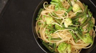 Spagetti sebzesi, bezelye, brokoli, çalı fasulyesi, kohlrabi vejetaryen makarna lezzetli makarna masanın üzerinde taze lezzetli gurme yemek.