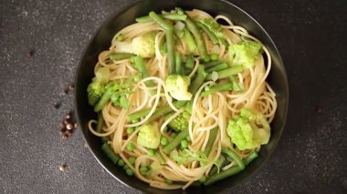 Spagetti sebzesi, bezelye, brokoli, çalı fasulyesi, kohlrabi vejetaryen makarna lezzetli makarna masanın üzerinde taze lezzetli gurme yemek.