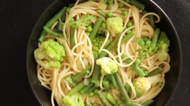 Spagetti sebzesi, bezelye, brokoli, çalı fasulyesi, kohlrabi vejetaryen makarna lezzetli makarna masanın üzerinde taze lezzetli gurme yemek.