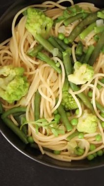 Spagetti sebzesi, bezelye, brokoli, çalı fasulyesi, kohlrabi vejetaryen makarna lezzetli makarna masanın üzerinde taze lezzetli gurme yemek.