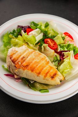 Izgara tavuk göğsü salatası, tavuk göğsü domates, yeşil yaprak marul, salata karışımı sebzeler doğal ürünler lezzetli çerezler lezzetli lezzetli gurme yemek arka planı masa sade üst görünüm fotokopi alanı keto ve paleo diyet vegan ve vejetaryen yemekleri