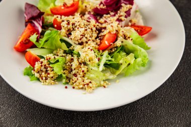 Kinoa salatası domates, yeşil yaprak salatası sebzeler... doğal ürün... lezzetli çerez... lezzetli gurme yemek... masanın üstünde... rustik üst görünüm... fotokopi alanı keto... ve paleo diyet vegan ve vejetaryen yiyecekler.