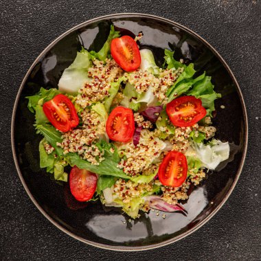 Kinoa salatası domates, yeşil yaprak salatası sebzeler... doğal ürün... lezzetli çerez... lezzetli gurme yemek... masanın üstünde... rustik üst görünüm... fotokopi alanı keto... ve paleo diyet vegan ve vejetaryen yiyecekler.