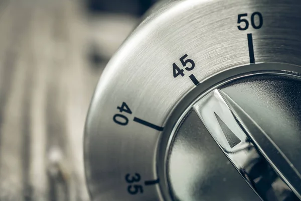 45 Minutes - Three-Quartes Of An Hour - Macro Of An Analog Chrome Kitchen Timer On Wooden Table