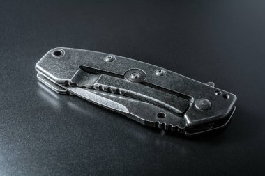 A tanıtıcısı siyah yansıma ile karanlık yere yatan bıçak katlama kapalı