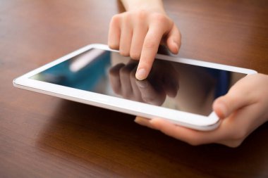 Kadın Holding ve bir masa üzerine beyaz bir Tablet dokunmadan