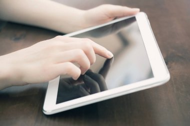 Kadın Holding ve bir masa üzerine beyaz bir Tablet dokunmadan