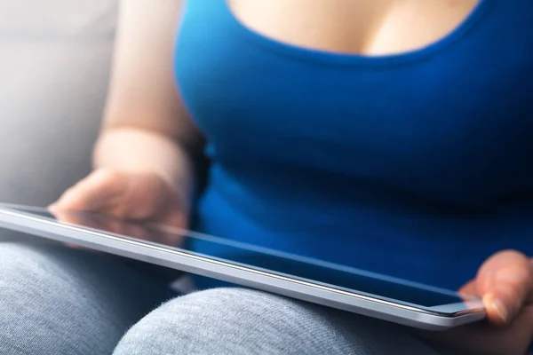 Vollbusige Frau im Tank-Top lehnt ein Tablett auf ihren Knien — Stockfoto