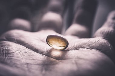 Jelatin hapı ortasında bir karanlık, kirli ve el, önden görünüm arıyorum kullanılan