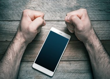 Quit Using Smartphone Or Social Media Concept With A White Mobile Phone Surrounded By 2 Stressed Looking Clenched Fists clipart
