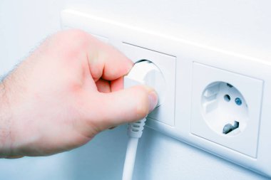 Enerji tasarrufu için duvar yuvasından bir elektrik fişini çekmek