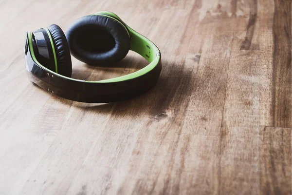 Grote zwarte draadloze hoofdtelefoons, liggend op een houten tafel — Stockfoto