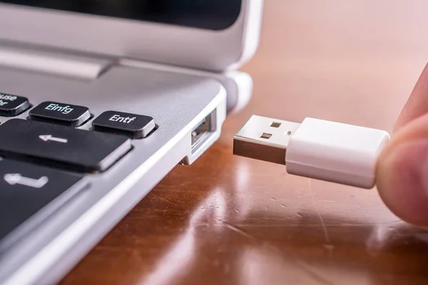 Erkek el Beyaz bir Usb kablosu küçük dizüstü Usb bağlantı noktasına bağlamayı