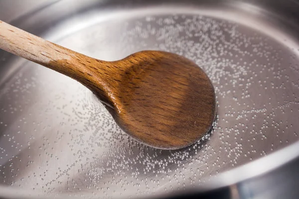 Houten koken lepel In een RVS Pot met kokend Water Stockfoto