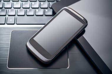 Siyah bir dizüstü bilgisayar, üstten görünüm klavye tablet yansıması ile siyah Smartphone