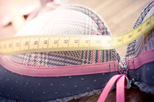 Macro Of A Bra With Measuring Tape On Top On A Table - Measure Breast Size Concept — Stock Photo, Image