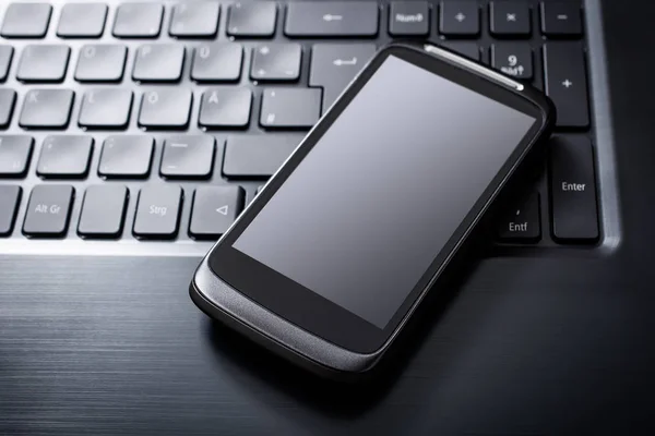 Siyah bir bilgisayar, üstten görünüm klavyede yalan yansıması ile siyah Smartphone — Stok fotoğraf