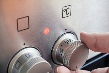 Kullanarak bir erkek el fırın sıcaklığı ayarlamak için denetimler yerleştir